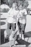  ??  ?? Anna Naquin (left) walks shelter dog Ellie May while her mother, Lisa Naquin, carries foster failure Jetta. The Naquin family fostered Jetta while she was nursing her two puppies and decided to add Jetta to their family through adoption. The Naquins...