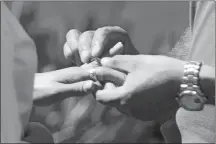  ?? ?? Armando Plascencia slips his ring on the hand of Carmen Paniagua during their wedding ceremony.