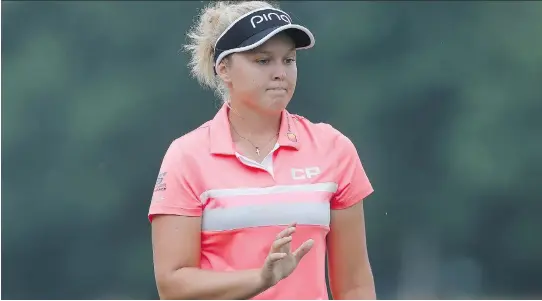  ?? MATT SULLIVAN/GETTY IMAGES ?? Brooke Henderson acknowledg­es the crowd after making par on the first hole of the second round of the U.S. Women’s Open on Friday.