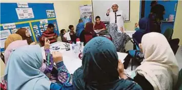  ??  ?? TENAGA pengajar Akademik Tahfiz Pekak Malaysia, Ustaz Ahmad Rozaimi Mohamed mengajar kelas bahasa dan mengaji isyarat bagi OKU pekak dan normal di Pusat Operasi OKU Berdaya Hulu Langat.