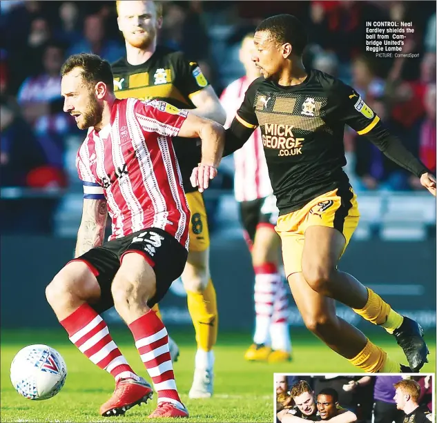  ?? PICTURE: CameraSpor­t ?? IN CONTROL: Neal Eardley shields the ball from Cambridge United’s Reggie Lambe