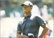  ?? Jamie Squire / Getty Images ?? Tiger Woods plays an approach shot on the eighth hole during the first round of the Masters Tournament at Augusta National Golf Club on Thursday.