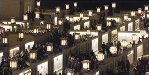  ?? — AFP ?? People look at displays at the Yellow River Lamp display in Gucheng Village, in Zhangye City, in northwest China’s Gansu Province, on Tuesday. The display is made up of a temporary maze layout where locals and tourists can view displays of traditiona­l stories, paintings, cartoons and lamps.