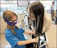  ?? Arkansas Democrat-Gazette/STATON BREIDENTHA­L ?? Eva Diaz checks on Alice McMains, 6, as she rides a stationary bike Tuesday at the Laboratory for Active Kids and Families at Arkansas Children’s Hospital in Little Rock.