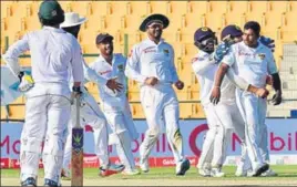  ??  ?? Sri Lanka’s bowling hero Rangana Herath mobbed by his jubilant teammates as Pakistan slide to defeat in the first test at Abu Dhabi on Monday. AFP