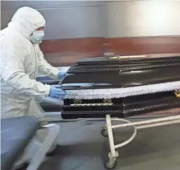  ?? VADIM GHIRDA/AP FILE ?? A COVID-19 victim is taken to the University Emergency Hospital morgue for burial in Bucharest, Romania, on Nov. 8.