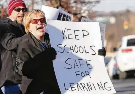  ?? PHIL MASTURZO / AKRON BEACON JOURNAL ?? Akron Public School teachers William Twigg (left) and Diane May protest before a scheduled school board meeting on Monday in Akron.