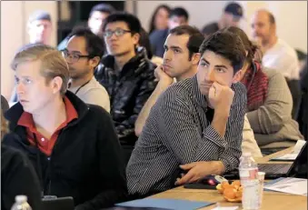  ?? JEFF CHIU/AP PHOTO ?? Segah Meer, right, and others listen to speakers during the FinCapDev San Francisco Hackathon, Feb. 8 in San Francisco. A record 1,500 hackathons around the world are planned for this year, and their focus is broadening from developing lucrative apps...