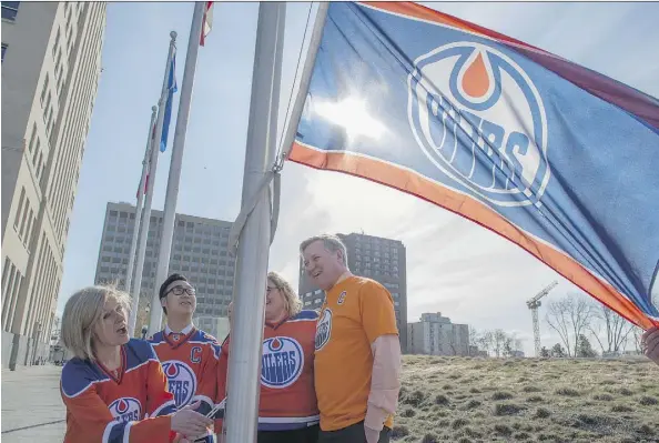  ?? SHAUGHN BUTTS ?? Premier Rachel Notley and her fellow NDP MLAs raise an Oilers flag Wednesday near the legislatur­e. A Calgary Flames flag was raised in Calgary at the same time by Finance Minister Joe Ceci. Notley and Ceci have a bet going to celebrate both teams being...