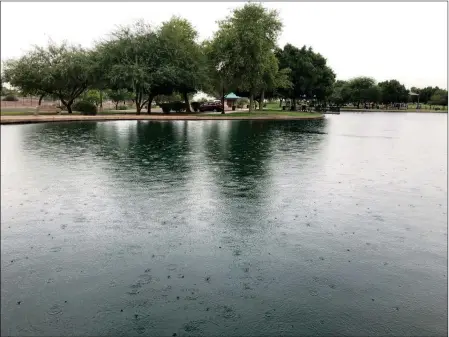  ?? Buy this photo at YumaSun.com PHOTO BY BLAKE HERZOG/YUMA SUN ?? RAINDROPS FALL ON THE LAKE AT WEST WETLANDS Park in Yuma Wednesday morning.