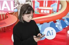  ?? — AFP photos ?? Lu Yu, head of Product Management and Operations of Wantalk, an artificial intelligen­ce chatbot created by Chinese tech company Baidu, scrolling through virtual character profiles on her phone, at the Baidu headquarte­rs in Beijing.