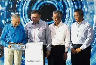  ??  ?? All aboard: Dr M and Loke launching the My100 and My50 unlimited travel pass for commuters at KL Sentral. Looking on are MOT officials.