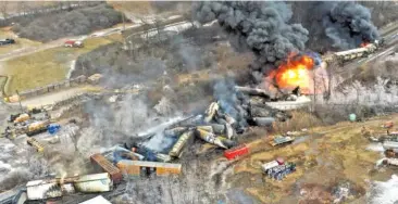  ?? AP PHOTO/GENE J. PUSKAR ?? Portions of a Norfolk Southern freight train that derailed the previous night in East Palestine, Ohio, remain on fire at mid-day on Feb. 4.