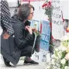  ?? LARS HAGBERG/AFP/GETTY IMAGES ?? A woman prays at a makeshift memorial for victims in the van attack in North York.