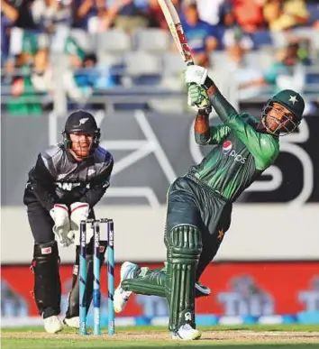  ?? AFP ?? Pakistan’s Fakhar Zaman goes for the big one as New Zealand’s Glenn Phillips watches during the second T20 match at Eden Park in Auckland yesterday.