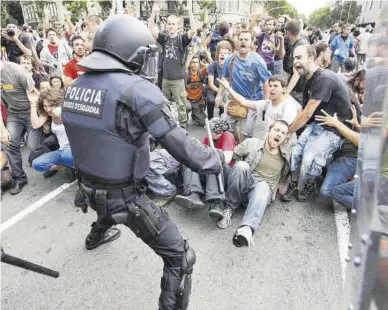  ?? DANNY CAMINAL ?? Miembros de los Mossos d’Esquadra intentan el desalojo de la plaza de Catalunya, el 27 de mayo de 2011.