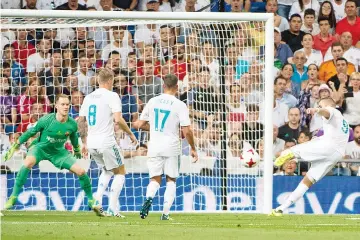  ??  ?? Real Madrid’s French forward Karim Benzema (R) scores their second goal during the second leg of the Spanish Supercup football match Real Madrid vs FC Barcelona at the Santiago Bernabeu stadium in Madrid - AFP photo