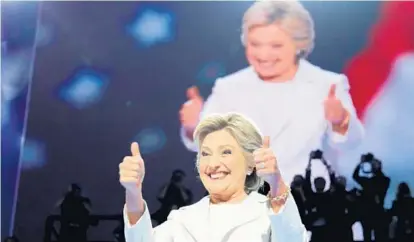 ?? CHIP SOMODEVILL­A/GETTY IMAGES ?? Hillary Clinton gives the crowd two thumbs up as she takes the stage at the Democratic National Convention.