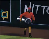  ?? HARRY HOW — GETTY IMAGES ?? A member of the Angels’ grounds crew removes an inflated plastic trash can thrown on to the field during the sixth inning against the Astros at Angel Stadium of Anaheim on Monday in Anaheim.