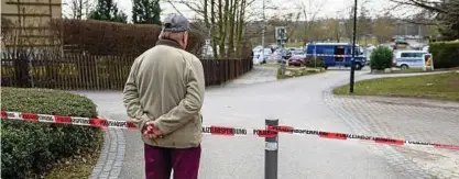  ?? Foto: Candy Welz, dpa ?? Ein Passant steht am . März vor der Polizeiabs­perrung nahe des Tatortes in Weimar West.