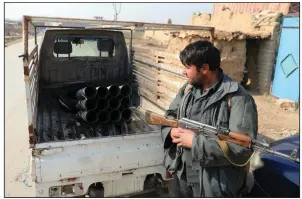  ?? (AP/Rahmat Gul) ?? An Afghan security official stands near a vehicle filled with rockets in Bagram last month. The U.S. military had met its goal of reducing the number of troops in Afghanista­n to about 2,500 by Friday.