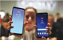  ??  ?? A HOSTESS shows up Samsung’s new S9 (R) and S9 Plus devices after a presentati­on ceremony at the Mobile World Congress in Barcelona, Spain on Feb. 25.