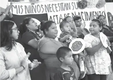  ?? Associated Press ?? Maria Francisca Rodriguez, center, holds her son Gustavo Martinez, 1, as people surroundin­g her applaud her during a news conference Monday at La Union del Pueblo Entero’s headquarte­rs in San Juan, Texas. Rodriguez is one of several members of a...