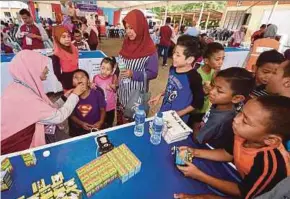  ?? PIC BY MOHD SYAFIQ RIDZUAN AMBAK ?? Children queuing up for deworming medication at the Felcra office in Hulu Berang yesterday.