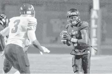  ?? Craig Moseley / Houston Chronicle ?? Hastings quarterbac­k Javon Williams, right, looks for an open receiver during the first quarter Friday night at Crump Stadium. Williams accounted for three touchdowns as the Bears clinched a playoff spot.