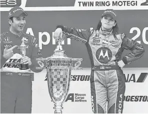  ??  ?? Danica Patrick on the podium celebratio­n in 2008 after winning the Indy Japan 300 at Twin Ring Motegi Superspeed­way: “The trophy was really funny. Just to have this giant trophy, and there’s such a great picture with Hélio and his trophy. And Hélio, being the character that he is, he of course embodied the look you’d have with a trophy that size next to mine. That was one of those memories.” AP