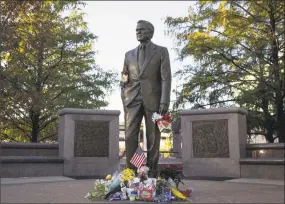  ?? Loren Elliott / AFP / Getty Images ?? A makeshift memorial in tribute to former President George H. W. Bush is seen at the foot of a monument in his honor in Houston on Sunday.