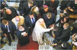  ?? ANDREW MEDICHINI AP ?? Pope Francis (center) blesses a boy in Gharb, Malta, on Saturday. The pope’s visit was intended to draw attention to Europe’s migration challenges.