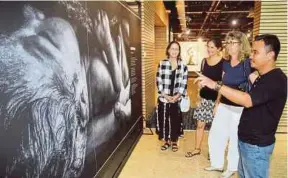  ?? PIC BY MAHZIR MAT ISA ?? NSTP photograph­er Sairien Nafis (right) explaining to visitors a photograph taken by him.