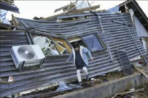 ?? Kyodo News via AP ?? A resident checks her destroyed house Friday in Wajima, Ishikawa prefecture, Japan.