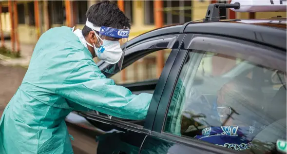  ?? Photo: Leon Lord ?? Medical frontliner Pritesh Chand swabs a member of the public during the first drive through swabbing services at Vunimono High School in Nausori on July 14, 2021.