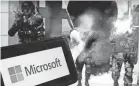  ?? ASSOCIATED PRESS ?? The logo for Microsoft, and a scene from Activision “Call of Duty - Modern Warfare,” are shown in this June 21 photo in New York, June 21, 2023. New broke Thursday that Microsoft will lay off 1,900 Activision Blizzard and Xbox employees months.