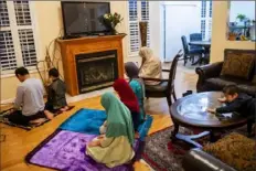  ?? Michael M. Santiago/Post-Gazette ?? The Ashfaq family prays the Maghrib during Ramadan on May 12 in Center. With mosques shut down because of the pandemic, the Ashfaqs — and many other Muslims — observed Ramadan almost entirely at home.