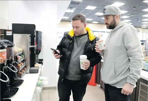  ?? PHOTOS: JULIO CORTEZ/THE ASSOCIATED PRESS ?? Lenny Sciascia and Mario Deangelis check on sporting events Sciascia bet on while grabbing coffee before heading back to Staten Island.