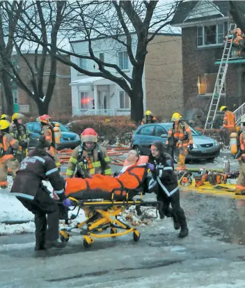  ?? PHOTO AGENCE QMI, SYLVAIN DENIS ?? Un pompier a été évacué en civière après avoir chuté au travers d’un plancher.