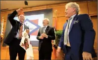  ?? Arkansas Democrat-Gazette/STATON BREIDENTHA­L ?? Home BancShares Chairman John Allison (right) and Gov. Asa Hutchinson (center) present Stonegate Bank CEO Dave Seleski a Hog hat and an ASU football jersey Monday during a news conference in Little Rock to announce Home BancShares’ purchase of...