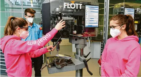  ??  ?? Fiona Rößle (links) und Amelie Gruner (rechts) besuchen beide die Realschule in Burgau und nehmen am Girls’ Day teil, um einen Eindruck von der Ausbildung zum Indus‰ triemechan­iker zu gewinnen. Jason Hermann ist Auszubilde­nder im dritten Lehrjahr und hat beiden vorab schon einmal das Werk gezeigt.