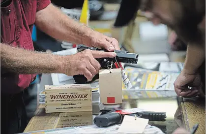  ?? MATHEW MCCARTHY WATERLOO REGION RECORD ?? A customer handles a pistol at Shooter's Choice in Waterloo on Thursday.