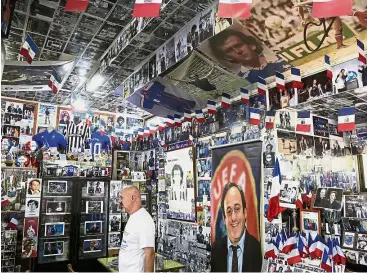  ?? — AP ?? Avid collector: Philippos Stavrou Platini stands by posters and collection­s of former football great and former UEFA president Michel Platini in his museum at Mosfiloti village on the island of Cyprus on Friday.