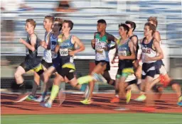  ??  ?? Runners make their way down the backstretc­h during the 800 meters in the state track and field championsh­ips in Mesa on May 3.