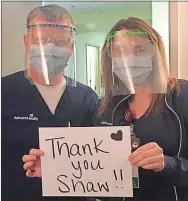  ?? Contribute­d ?? Sonia Clark and Kevin Rodman hold a sign showing their appreciati­on to Shaw Industries for donating face shields to the hospital.