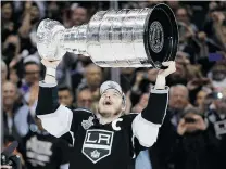  ?? JAE C. HONG/ THE ASSOCIATED PRESS ?? Los Angeles Kings captain Dustin Brown raises the Stanley Cup after defeating the New York Rangers on Friday in Los Angeles.