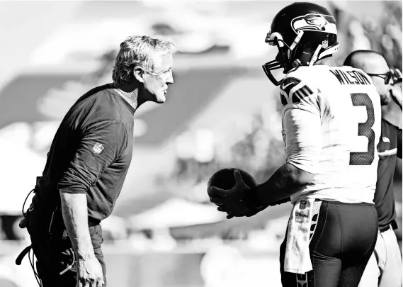  ?? HARRY HOW, GETTY IMAGES ?? Coach Pete Carroll, speaking with quarterbac­k Russell Wilson, is seeking his sixth playoff berth in seven years with the Seahawks.