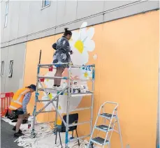  ?? Photo / Dan Hutchinson ?? Claudine Mailei hard at work on her picture in a prime part of the alleyway connecting Roberts St and Tuwharetoa St.