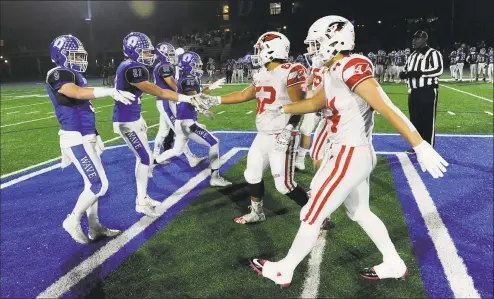  ?? Matthew Brown / Hearst Connecticu­t Media ?? Players from Darien, left, and Greenwich shake hands before a Class LL state quarterfin­al in December.