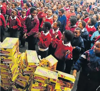  ?? Picture: SUPPLIED ?? GIVING BACK: Project Khulisanan­i hands over school shoes to Khanyisa Primary School pupils as part of their Back to School Campaign last year